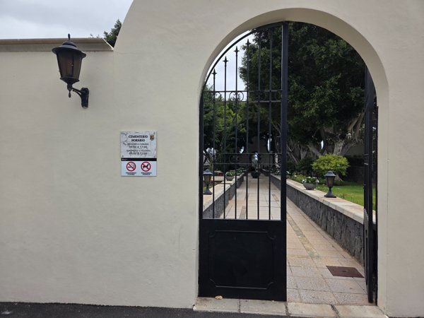 Eingang zum Friedhof von Adeje mit gepflegtem Garten und alter Baumbestand – ein Ort der Ruhe.