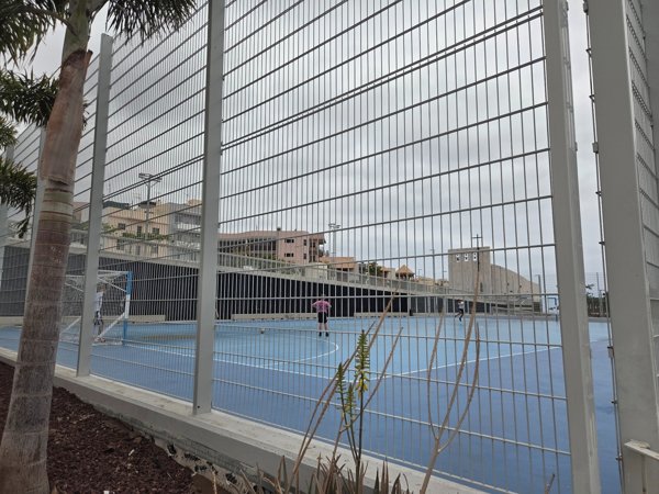 Sportplatz mit blauen Feldern und Kindern beim Spielen – ideal für Freizeitaktivitäten.